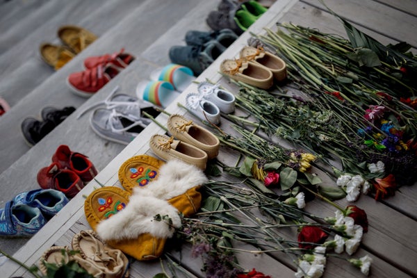 Flowers, shoes and moccasins sit on stairs.
