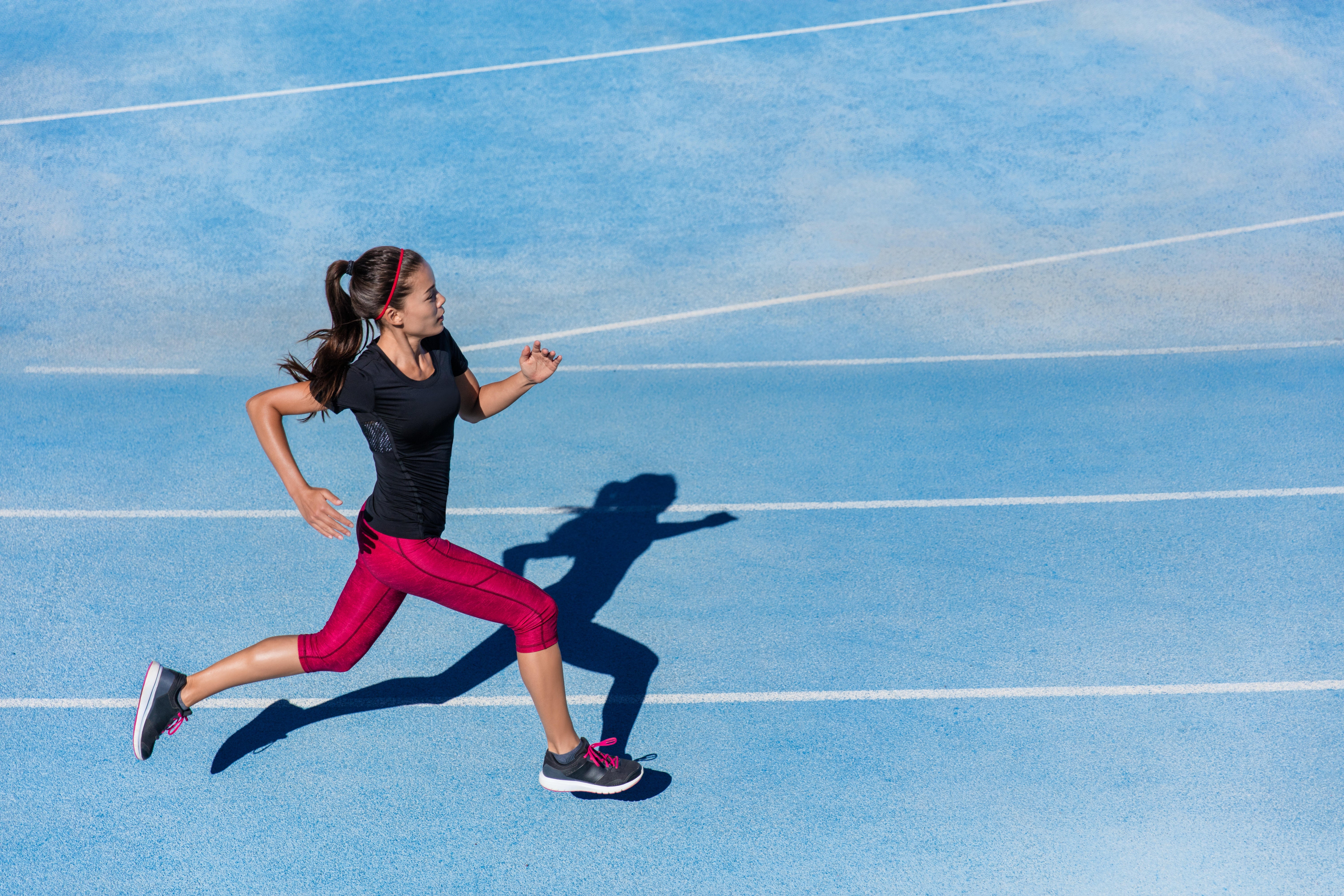 Female track and field athletes running on sunny track Stock Photo - Alamy