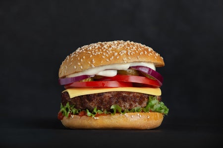 Hamburger with bun and dressing on a black background