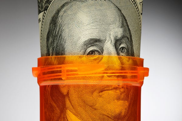 Close up of an orange prescription bottle with Benjamin Franklin on a $100 bill rolled up inside